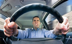A furious man driving, as seen from behind the wheel. Shot using a very wide fisheye lens.